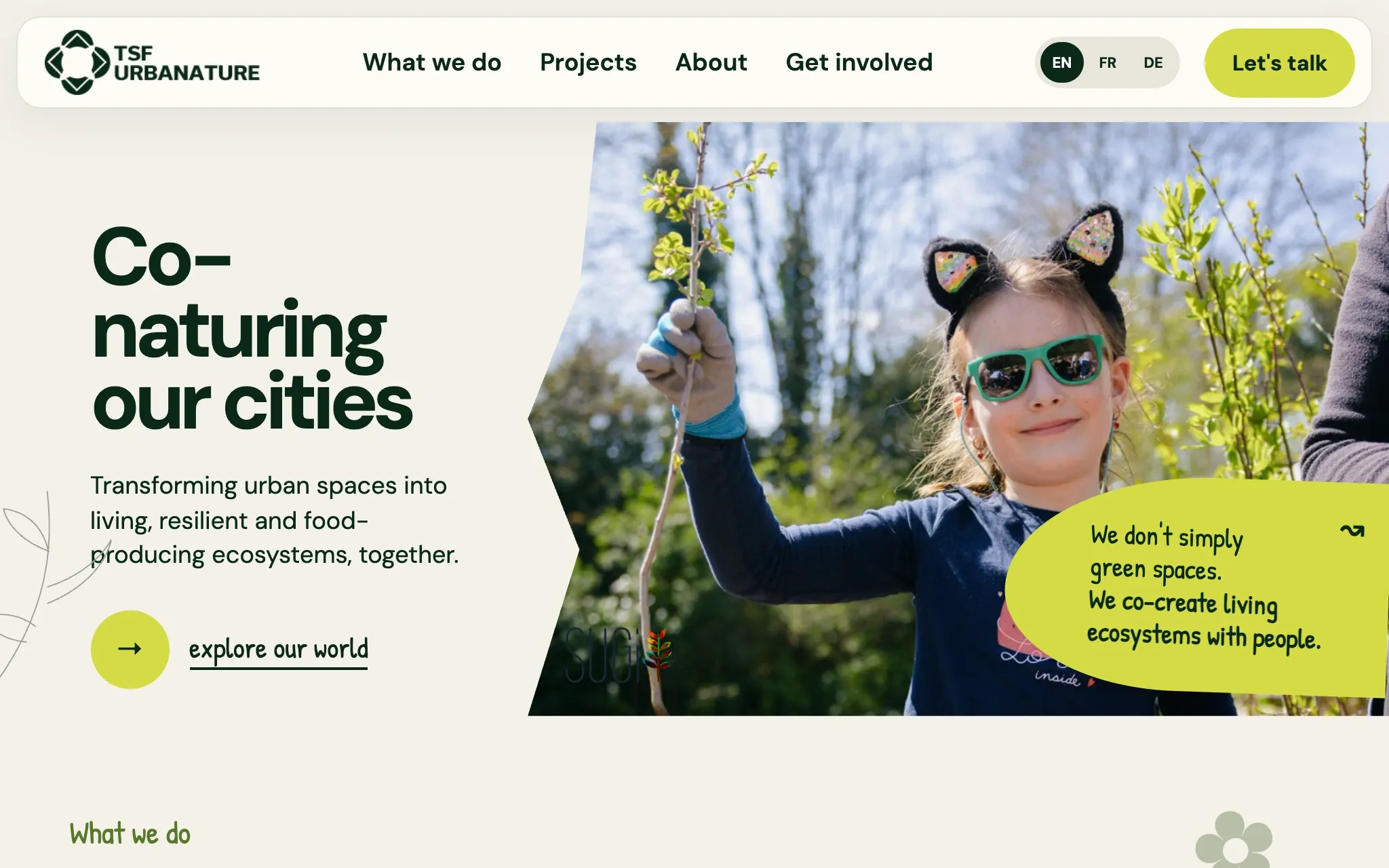 The new homepage’s first screen: a header with four menu items and a language switch, the headline “Co-naturing our cities”, and a photo of a child planting.